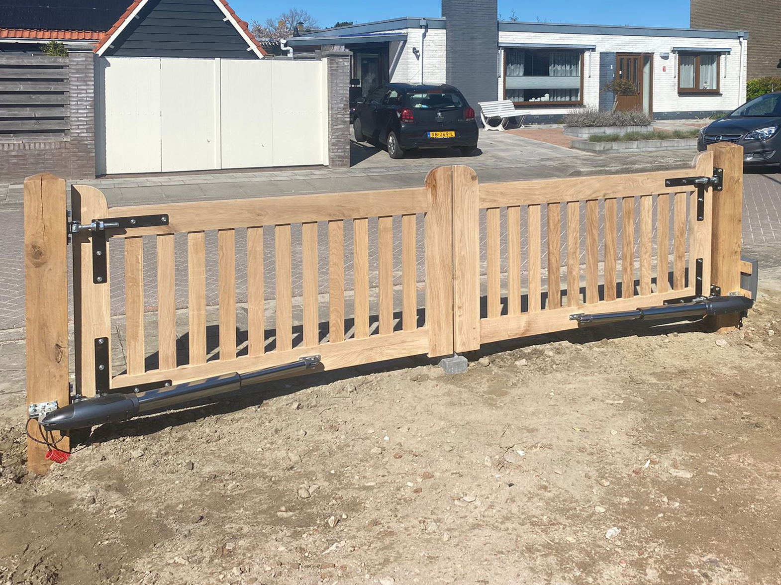 Montage: Elektrisch bediende eikenhouten poort.